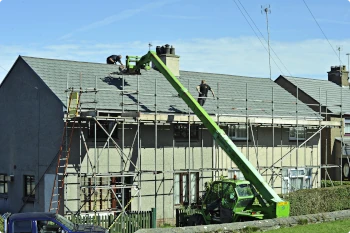 roofers from vreeland roofing changing roof with scaffold and crane